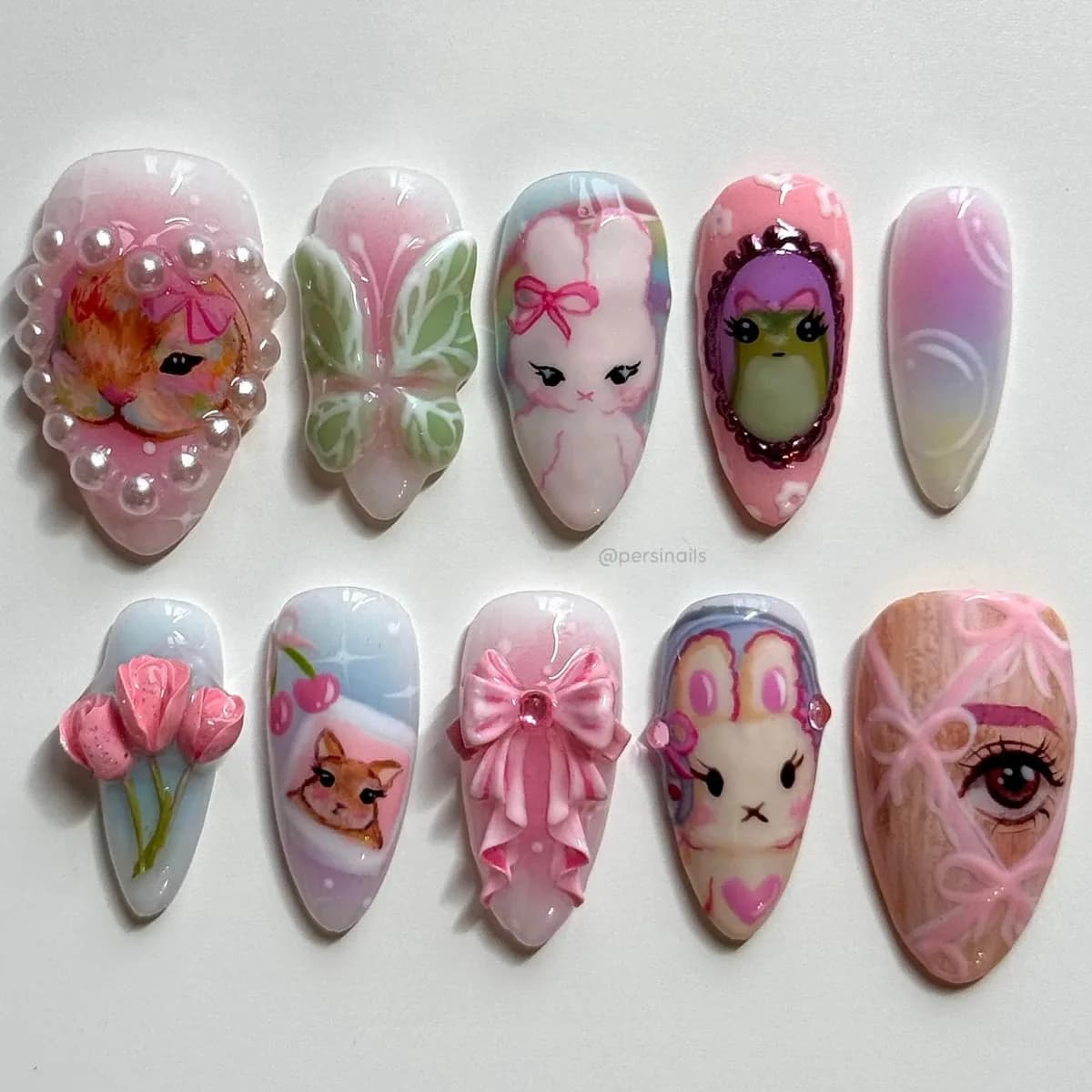 Ten press-on nails in milky nude and pastel, with a hand-painted rabbit and kitten, sculpted tulips and blush bows.