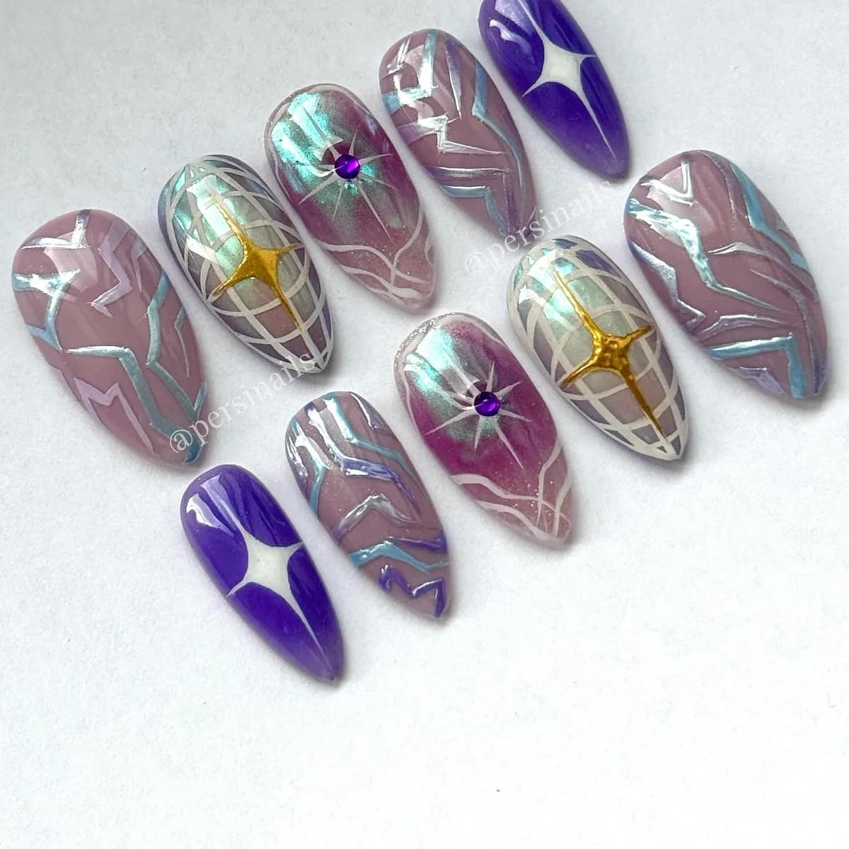 Ten press-on nails in colour-shifting mirror chrome, with crystals set by hand at the centre of small four-point stars.